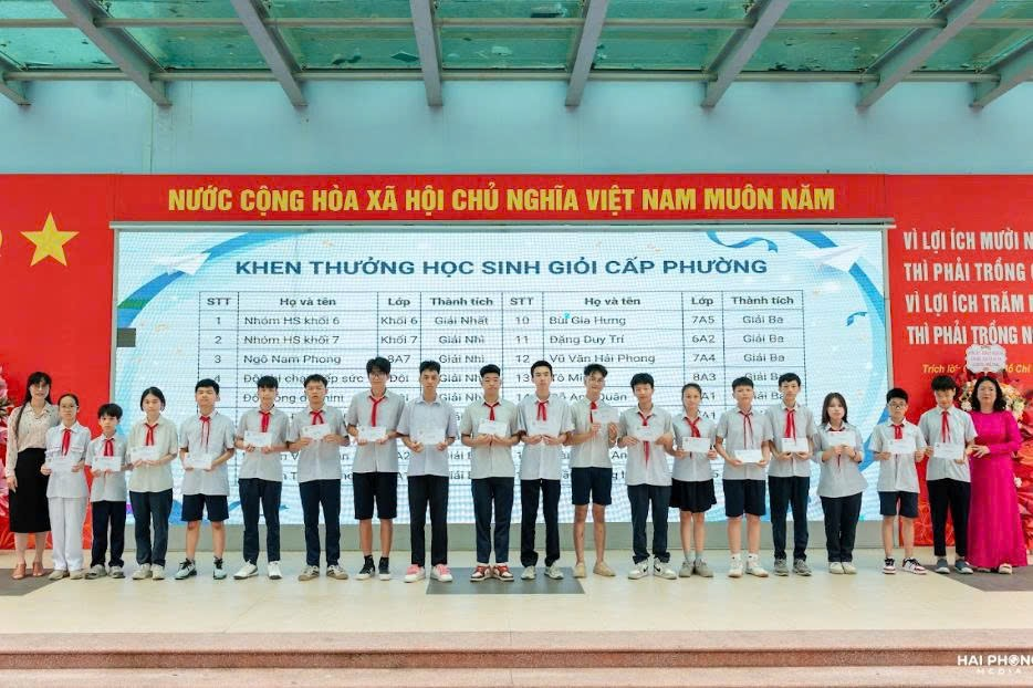 A group of people standing in front of a large signDescription automatically generated