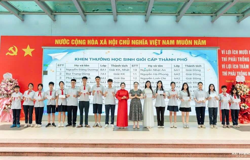 A group of people standing in front of a large signDescription automatically generated
