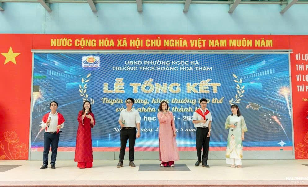 A group of people standing on a stageDescription automatically generated