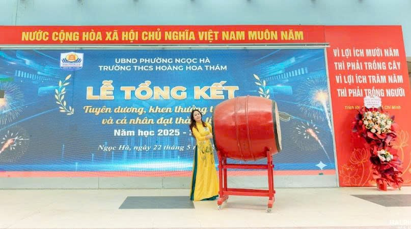 A person standing next to a large drumDescription automatically generated