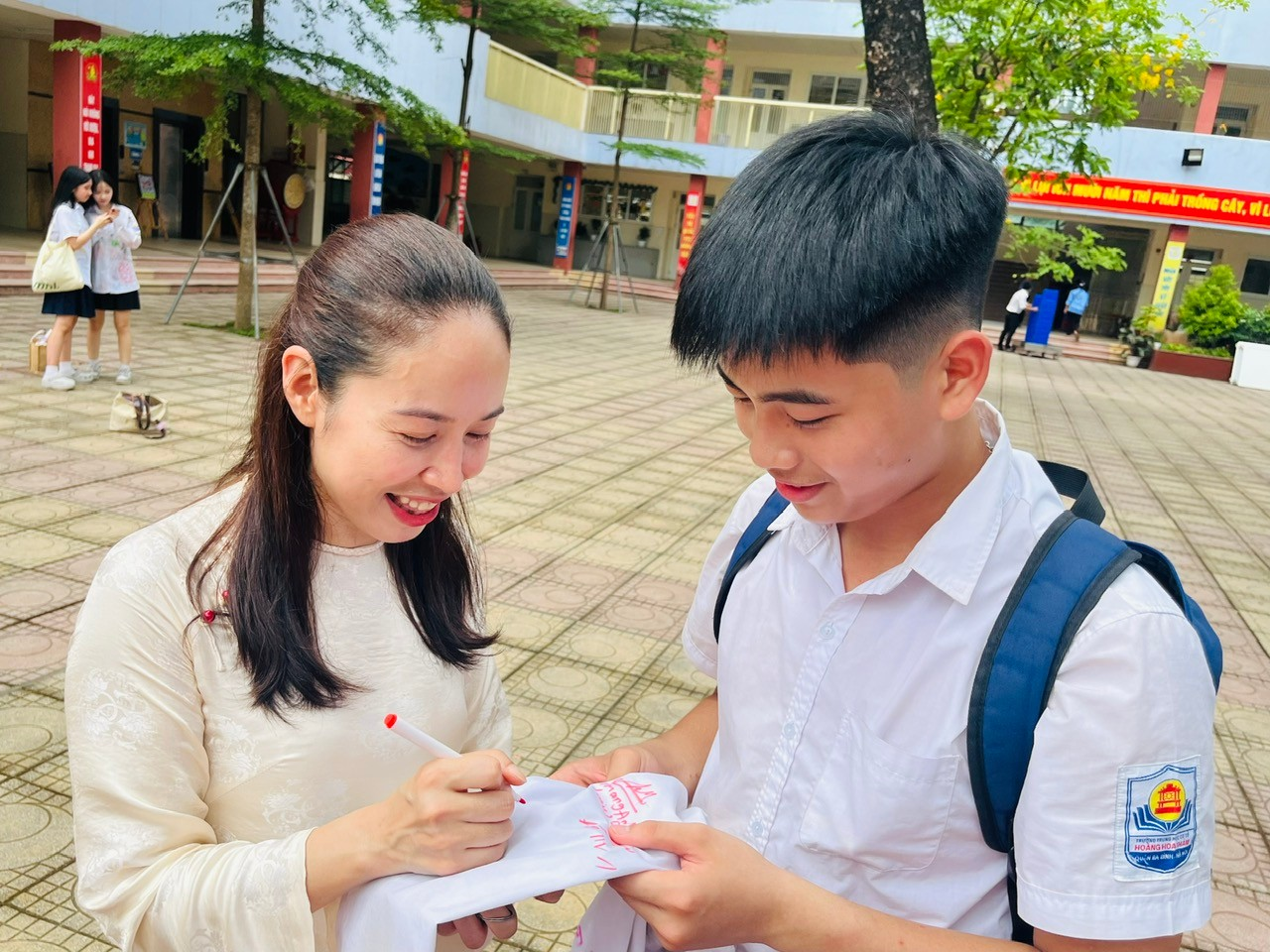 A person and person signing something on a piece of paperDescription automatically generated