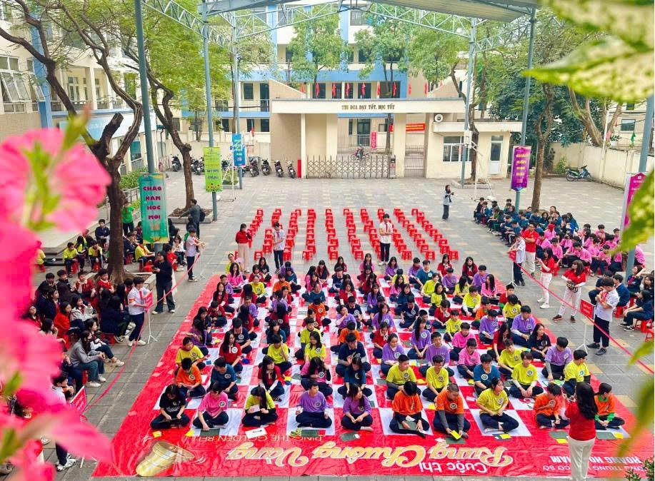 A group of people sitting on a red and white blanketDescription automatically generated