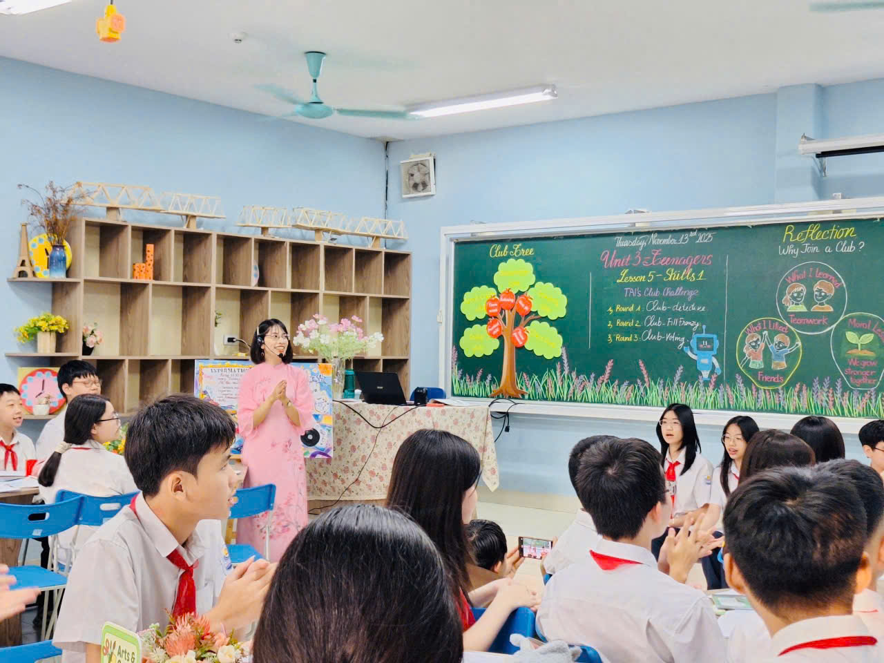 A person standing in front of a group of people in a classroomDescription automatically generated
