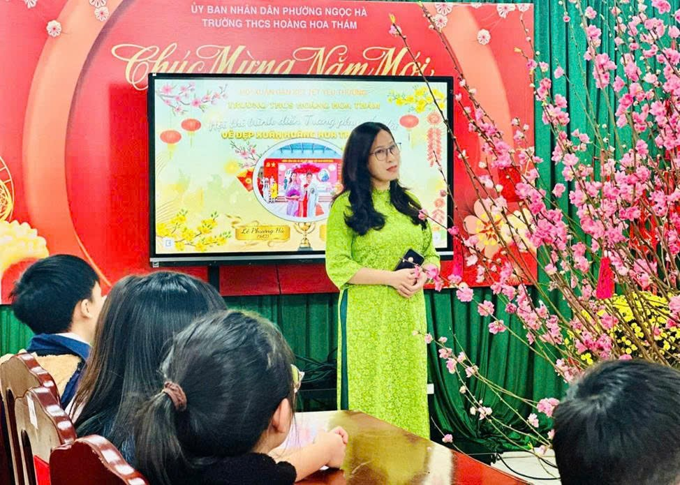 A person in a green dress standing in front of a screen

Description automatically generated