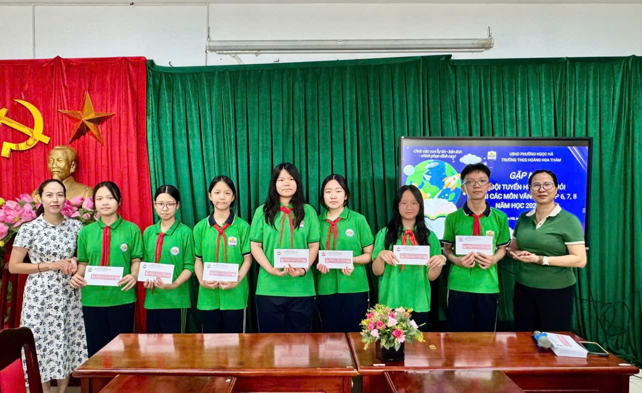 A group of people standing in front of a green curtain

Description automatically generated
