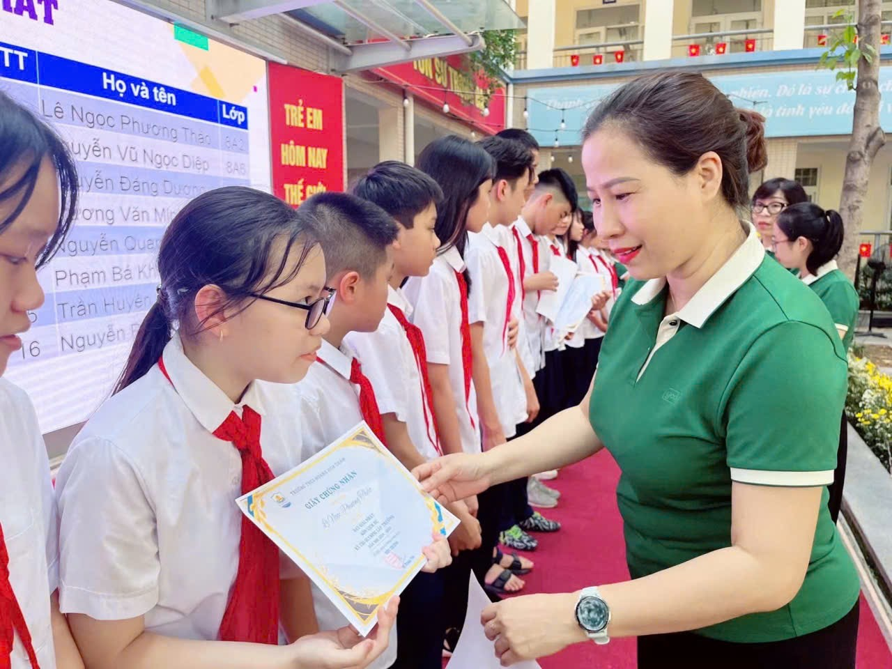 A person holding a paper with a group of people in the background

Description automatically generated