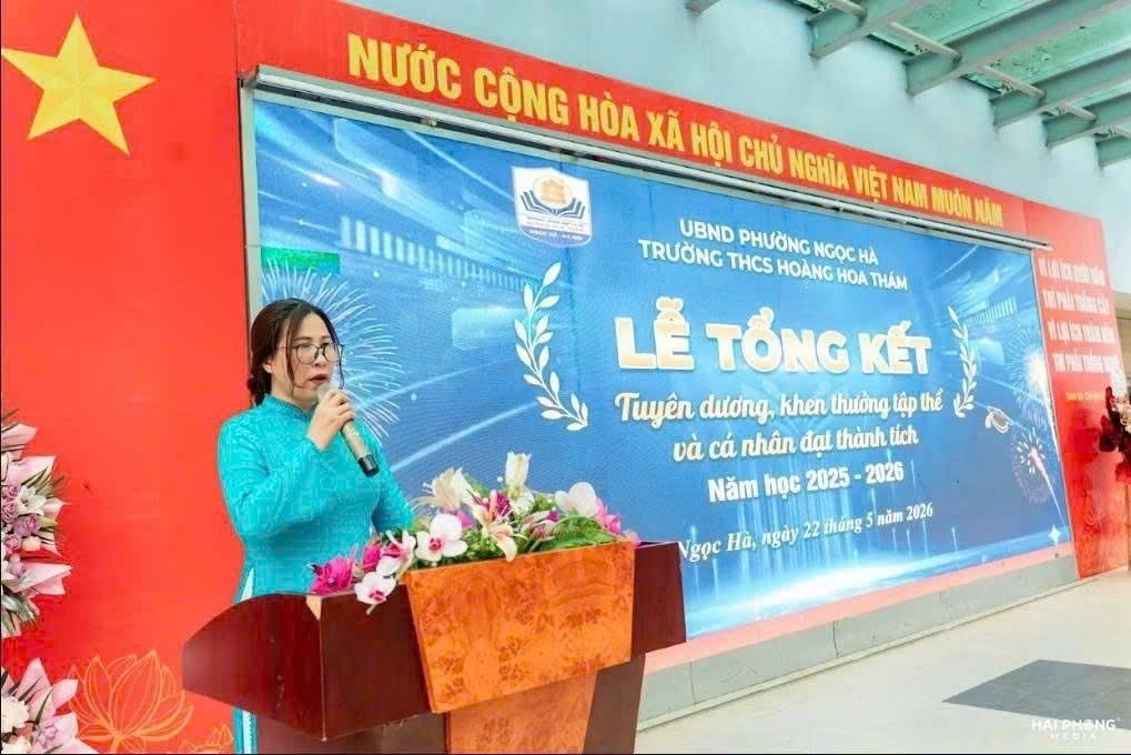 A person standing at a podium with a microphone

Description automatically generated
