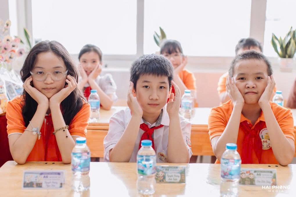 A group of kids sitting at a desk

Description automatically generated
