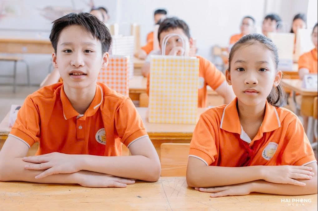 A group of kids sitting at a desk

Description automatically generated