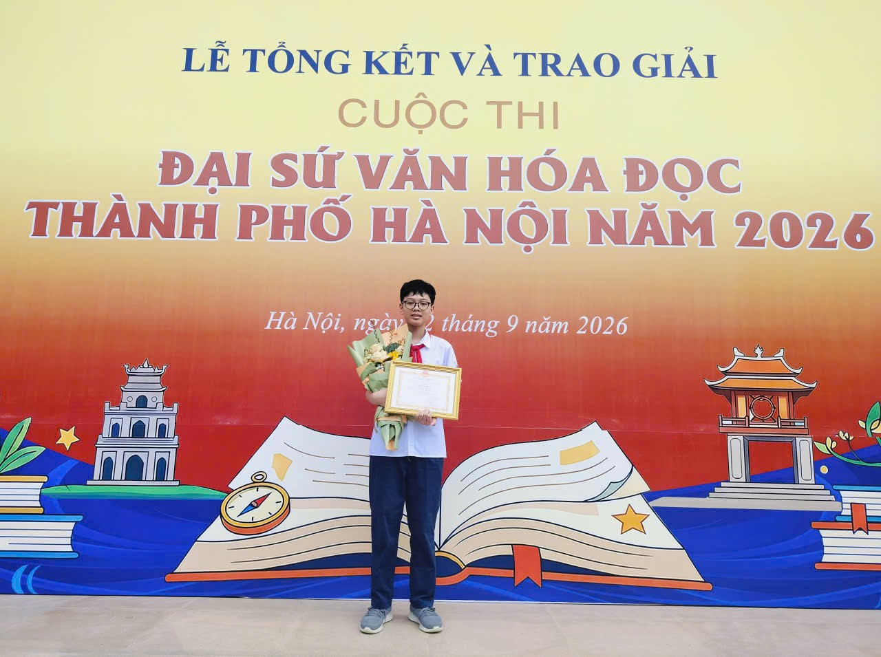 A person standing in front of a bannerDescription automatically generated